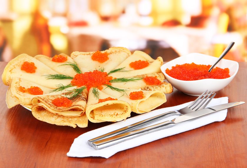 19625794 - delicious pancakes with red caviar on table in cafe